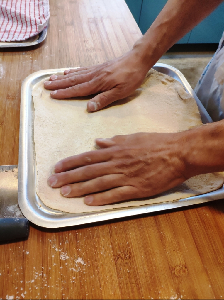 Pizza dough on baking sheet